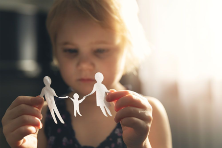 a child holding up a paper family