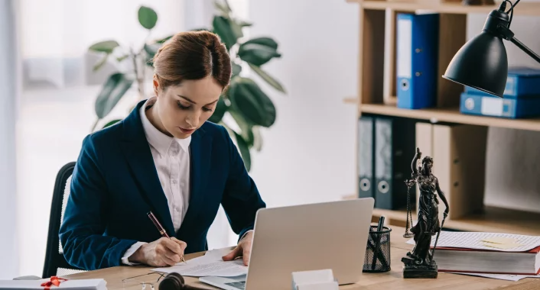 a woman at a desk signing something.