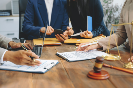 people at a conference table signing documents.