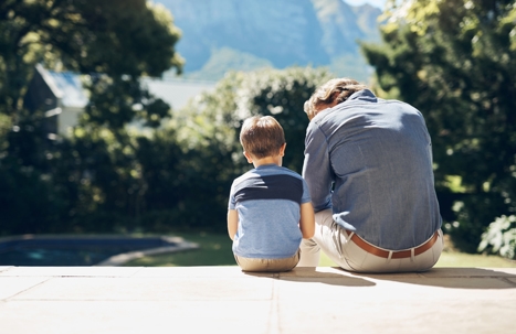 Father and son sitting outside together